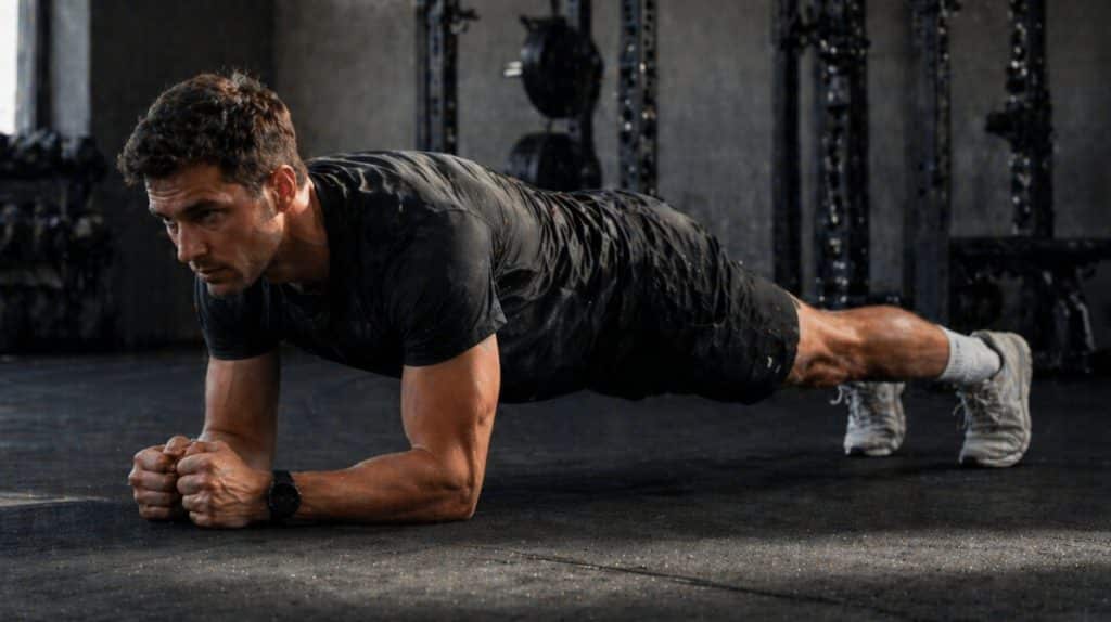 mand som laver planken i et fitnesscenter